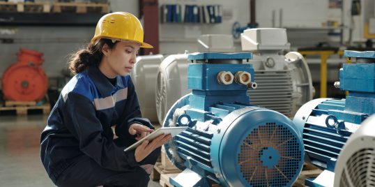 young serious female engineer in protective helmet